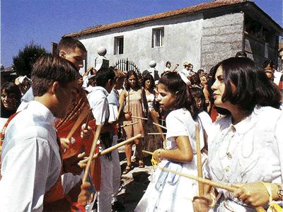 Los danzantes entrechocan sus palitos, bailando y abriendo la procesión